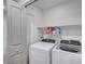 Well-lit laundry room features a modern washer and dryer set and functional shelving at 622 Quaint Acres Ave, Las Vegas, NV 89183