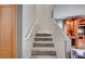 Carpeted stairway to the second floor with a wooden door and a handrail at 622 Quaint Acres Ave, Las Vegas, NV 89183