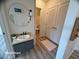 Stylish bathroom with a modern vanity, round mirror, and linen closet at 6313 Snap Ridge St # 201, North Las Vegas, NV 89081