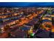 Expansive aerial view of a well-planned community, with tree-lined streets and mountain views in the distance at twilight at 6630 Virtuoso Ct, Las Vegas, NV 89139