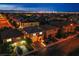 Night aerial view showcasing a residential neighborhood with city skyline views, and illuminated streets at 6630 Virtuoso Ct, Las Vegas, NV 89139