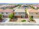 Aerial view of a lovely home showcasing a manicured lawn, mature trees, and a welcoming entrance at 6630 Virtuoso Ct, Las Vegas, NV 89139