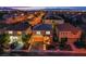 Aerial view of a well-lit suburban neighborhood with manicured lawns at twilight at 6630 Virtuoso Ct, Las Vegas, NV 89139