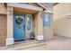 Charming front entrance with a blue door, seasonal wreath, and decorative potted plants at 6630 Virtuoso Ct, Las Vegas, NV 89139