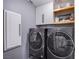 Laundry room featuring side-by-side washer and dryer, cabinets, and shelving for laundry essentials at 6630 Virtuoso Ct, Las Vegas, NV 89139