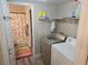 Functional laundry area with washer, dryer, shelving, and adjacent bathroom at 6800 E Lake Mead Blvd # 1126, Las Vegas, NV 89156