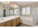 This bright bathroom features a double vanity, soaking tub, and separate shower at 6826 Dovecote Ave, North Las Vegas, NV 89084