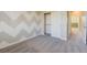 Bedroom featuring a chevron wall design, plush carpeting, and natural light at 6826 Dovecote Ave, North Las Vegas, NV 89084