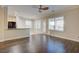 Living room features wood floors, neutral paint, ceiling fan, and an open layout to the kitchen at 6826 Dovecote Ave, North Las Vegas, NV 89084