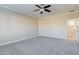 The main bedroom features neutral walls, carpet, a ceiling fan and an ensuite bathroom at 6826 Dovecote Ave, North Las Vegas, NV 89084