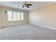 This carpeted main bedroom features light-colored walls and large windows at 6826 Dovecote Ave, North Las Vegas, NV 89084