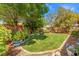 Lush backyard featuring healthy lawn, mature shade trees, and brick perimeter at 7252 Royal Melbourne Dr, Las Vegas, NV 89131