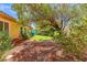 Secluded backyard with rock ground cover, mature trees, and healthy green lawn at 7252 Royal Melbourne Dr, Las Vegas, NV 89131