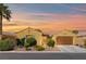 Charming single-story home with desert landscaping and a warm, inviting facade at sunset at 7252 Royal Melbourne Dr, Las Vegas, NV 89131