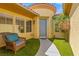 Charming front porch featuring an decorative chair, attractive front door and a manicured lawn at 7252 Royal Melbourne Dr, Las Vegas, NV 89131
