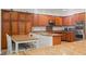 Open kitchen featuring an island, granite counters, stainless appliances, and wood finish cabinets at 7252 Royal Melbourne Dr, Las Vegas, NV 89131