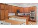 Eat-in kitchen featuring an island, granite counters, and wood finish cabinets and flooring at 7252 Royal Melbourne Dr, Las Vegas, NV 89131