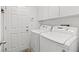 Clean laundry room featuring white washer and dryer with adjacent utility cabinets at 7252 Royal Melbourne Dr, Las Vegas, NV 89131