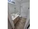 Neutral bathroom with wood-look floors, a tub and shower combination, and large mirror above the vanity at 79 Magical Mystery Ln, Henderson, NV 89074