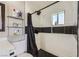 Tiled bathroom featuring a shower with white walls and black accents, plus floating shelves for storage at 80 E Texas Ave, Henderson, NV 89015