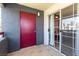 Exterior balcony with a red storage door and sliding glass doors, offering a view of the community at 8600 W Charleston Blvd # 2085, Las Vegas, NV 89117