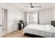 This bright bedroom features wood-look floors, a ceiling fan, and a window with natural light at 8600 W Charleston Blvd # 2085, Las Vegas, NV 89117