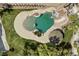 Overhead shot highlighting the pool area with a rock waterfall, spa, tiki hut, and manicured landscaping at 8970 Lansberry Ct, Las Vegas, NV 89147