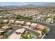 A high-angle aerial view highlights the community, palm tree lined streets and mountain views at 8970 Lansberry Ct, Las Vegas, NV 89147
