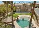 Aerial view of home showcasing the backyard pool with tiki hut and rock features, surrounded by lush greenery at 8970 Lansberry Ct, Las Vegas, NV 89147
