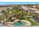 Aerial view of the property showcasing the pool with rock features, tiki hut, and surrounding neighborhood at 8970 Lansberry Ct, Las Vegas, NV 89147