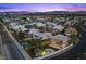 Expansive aerial view of a residential neighborhood with palm trees and mountain views at sunset at 8970 Lansberry Ct, Las Vegas, NV 89147