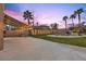 Spacious backyard featuring a large patio area, lush green lawn, and a pool in the distance at 8970 Lansberry Ct, Las Vegas, NV 89147