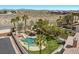 Relaxing backyard featuring a pool with slide, a tiki hut, and a green lawn with mature landscaping at 8970 Lansberry Ct, Las Vegas, NV 89147