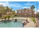 Stunning backyard featuring a custom pool, lush landscaping, and ample space for entertaining at 8970 Lansberry Ct, Las Vegas, NV 89147
