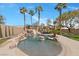 Resort-style backyard with a custom pool featuring a rock waterfall and lush tropical landscaping at 8970 Lansberry Ct, Las Vegas, NV 89147