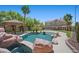Lush backyard featuring a pool with rock features, a tiki hut, and a well-maintained lawn at 8970 Lansberry Ct, Las Vegas, NV 89147