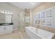 Luxury bathroom boasting a soaking tub, glass shower, vanity, and marble floors at 8970 Lansberry Ct, Las Vegas, NV 89147