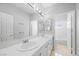 Bright bathroom featuring a double vanity, large mirror, and separate toilet and bath area at 8970 Lansberry Ct, Las Vegas, NV 89147