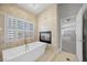 Elegant bathroom featuring a soaking tub, fireplace and view to the main bedroom at 8970 Lansberry Ct, Las Vegas, NV 89147