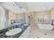 Primary bathroom with dual sinks, soaking tub, fireplace, and marble countertops at 8970 Lansberry Ct, Las Vegas, NV 89147