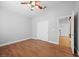 A bright bedroom features hardwood floors, a ceiling fan and a closet with paneled doors at 8970 Lansberry Ct, Las Vegas, NV 89147