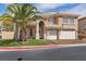 Charming two-story home featuring a well-manicured lawn, a palm tree, and a two-car garage at 8970 Lansberry Ct, Las Vegas, NV 89147