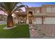 A charming two-story home with a manicured lawn, a brick driveway, and professional landscaping at 8970 Lansberry Ct, Las Vegas, NV 89147