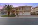 Elegant two-story home with a well-manicured lawn, brick driveway, mature landscaping and a two-car garage at 8970 Lansberry Ct, Las Vegas, NV 89147