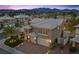 This two-story home features a three car garage, desert landscaping, and a covered front porch at 8970 Lansberry Ct, Las Vegas, NV 89147