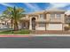 Charming two-story home featuring a well-manicured lawn, a palm tree, and a two-car garage at 8970 Lansberry Ct, Las Vegas, NV 89147