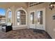 Close up of a front entrance with decorative glass doors, arched windows, and stone pavers at 8970 Lansberry Ct, Las Vegas, NV 89147