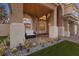 Inviting front porch with decorative columns, seating, and desert landscaping at 8970 Lansberry Ct, Las Vegas, NV 89147