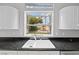 The kitchen sink features backyard views, with white cabinets and dark countertop at 8970 Lansberry Ct, Las Vegas, NV 89147