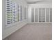 Bright living room with plantation shutters on windows and neutral colored carpet at 8970 Lansberry Ct, Las Vegas, NV 89147